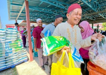 SEORANG penduduk gembira ketika menerima sumbangan makanan termasuk sekampit beras 10kg pada Majlis Wakalah Zakat Andalusia Travel and Tours bersama Ayam Bismi di Alor Setar. -UTUSAN/JAMLIAH ABDULLAH