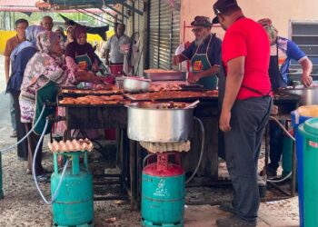 PELANGGAN beratur panjang sehingga 100 meter seawal pukul 3 petang bagi membeli martabak di gerai Muhammad Nazir Muhammad Ashraf, 64, di Kampung Guar Halban, Jalan Mata Ayer, Arau, Perlis, semalam. -UTUSAN/ASYRAF MUHAMMAD