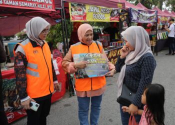 ROSNAH Sardi (tengah) menyampaikan maklumat kepada masyarakat mengenai Kempen Bijak Membantu Elak Tertipu ketika menyertai Op Ramadan 'Helping The Vagrant Community' di Nilai, Seremban, semalam.-UTUSAN/NUR SHARIEZA ISMAIL.