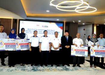 Aznan Tamin (enam dari kanan) bersama penerima geran Program Pendidikan Kelestarian  pada Majlis Nota Persefahaman (NoU) Kerjasama Antara Uda Land (South) Sdn. Bhd. dan Jabatan Pendidikan Negeri Johor di Wisma SBBU, Johor Bahru hari ini. UTUSAN/RAJA JAAFAR ALI