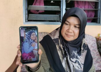 ZAIRON Mamat menunjukkan gambar anak perempuannya yang hilang di Kuala Terengganu sejak 7 Oktober tahun lalu. - UTUSAN/KAMALIZA KAMARUDDIN