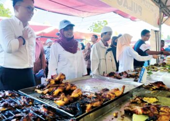 DANIEL Gooi (kiri) ketika meninjau suasana bazar Ramadan di Bayan Baru, Pulau Pinang. – MINGGUAN/IQBAL HAMDAN
