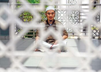 Muhammad Yusuff Mohd. Azam, 28, membaca Al-Quran Braille bagi mengimarahkan  bulan Ramadan di Masjid Seberang Takir, semalam. 
– UTUSAN/PUQTRA HAIRRY ROSLI