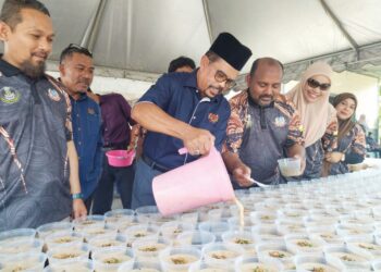 ADNAN Mat menuang bubur lambuk dalam majlis penyerahan bubur lambuk oleh Gabungan Kesatuan Pekerja-Pekerja Dalam Perkhidmatan Kerani dan Bersekutu Kerajaan (Auegcas) di Ipoh semalam.