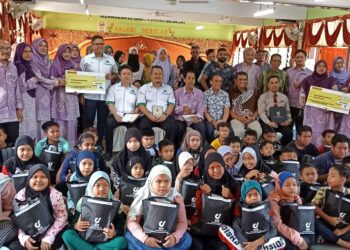 MURID SK Changkat Jong yang menerima bantuan persekolahan dalam Program Back to School dan Menyantuni Anak Yatim dan Asnaf anjuran bersama Gas Malaysia Berhad (Gas Malaysia) dan Central Medicare di Teluk Intan hari ini. - UTUSAN