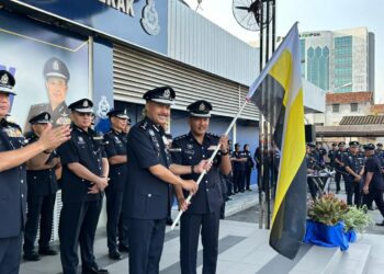 MOHD. Yusri Hassan Basri (kiri) menyerahkan bendera negeri Perak kepada Pengurus Pasukan Lumba Basikal Kontinjen Perak, Asisten Superintenden Shaiful Irwan Mohd. Ali pada Perhimpunan Bulanan Ketua Polis Perak di pekarangan IPK Perak, Ipoh hari ini. - UTUSAN
