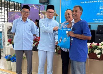 MOHD. Azizi Abu Naim menyampaikan sumbangan kepada penduduk di Rancangan Kemajuan Tanah (RKT) Kesedar Jeram Tekoh di Gua Musang, Kelantan. -UTUSAN/AIMUNI TUAN LAH.