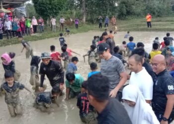 Tengku Hassanal Ibrahim Alam Shah (bertopi) bersama penduduk memadap ikan di petak sawah Kampung Guntong, Jerantut, Pahang - UTUSAN/HARIS FADILAH AHMAD