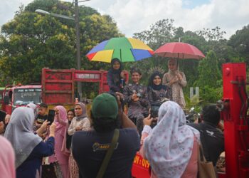 MOHD. Badrul Haikal Mohd. Bakri dan pasangannya, Nurul Nazifah Ismail diarak menaiki trak tunda pada hari persandingan mereka di Kampung Rawai, Marang, semalam. - UTUSAN/PUQTRA HAIREY ROSLi