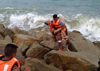 ANGGOTA bomba mengusung salah seorang kanak-kanak yang ditemukan lemas ketika mandi di Pantai Teluk Lipat, Dungun, petang tadi.