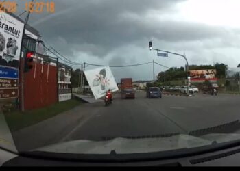 TANGKAP layar video memaparkan seorang penunggang motosikal dihempap papan iklan ketika angin kencang dalam kejadian di persimpangan lampu isyarat berdekatan Masjid Tengku Mahkota Abdullah Jerantut di Jerantut, Pahang.
