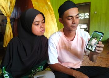 SHAHRIR Abdur Rahman (kanan) menunjukkan gambar Shahidan yang maut kemalangan di Wakaf Bharu, Tumpat, Kelantan-UTUSAN/ROHANA ISMAIL.