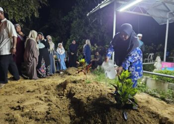 HAMSAH Omar menyiram air di pusara Allahyarham Wan Muhammad Haikal Wan Hussin di Tanah Tanah Perkuburam Islam Kampung  Alor Selising, Jertih, Besut, sebentar tadi.