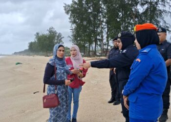 MAIZURA Abdul Kadir (dua, kanan) menasihatkan pengunjung untuk tidak menghampiri pantai ketika mengadakan pemantauan di Pantai Teluk Lipat, Dungun, hari ini. - UTUSAN/NIK NUR IZZATUL HAZWANI NIK ADNAN/