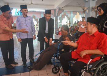 SHAIKH Harun Shaikh Ismail (tiga dari kiri) menyampaikan sumbangan zakat kepada orang kurang upaya pada Program Agihan Bantuan Zakat Sempena Ramadan di Kuala Terengganu, hari ini. - UTUSAN/PUQTRA HAIRRY ROSLI
