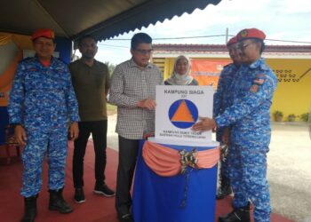 AMINURRAHIM Mohamed (kanan) melancarkan Kampung Siaga 211: Komuniti Berdaya Tahan Bencana APM Kampung Bukit Tadok, Hulu Terengganu, hari ini . - UTUSAN/NOOR HAYATI MAMAT