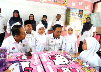 AZMAN Adnan (tiga dari kanan) bersama  Aznan Tamin (kiri) beramah mesra dengan murid tahun satu ketika mengadakan lawatan pada hari pertama persekolahan di SK (P) Sultan Ibrahim, Johor Bahru.