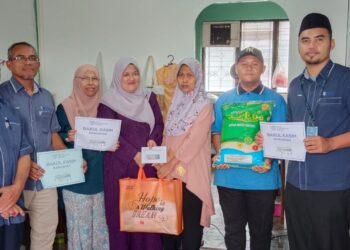 NORLELAWATI Md. Akim (empat dari kiri) menyampaikan bantuan barangan dapur kepada Norzana Wahid  (tiga dari kanan) ibu kepada Muhammad Fairuz Peldaus (dua dari kanan) di Blok 53, Flat Taman Tun Aminah, Johor Bahru.