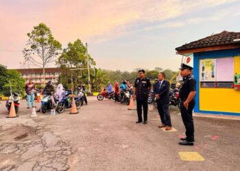 JAMALUDIN Baharun (dua dari depan) bersama dua anggota polis selaku Pegawai Perhubungan Sekolah memantau suasana hari pertama sekolah dibuka di pintu masuk Sekolah Kebangsaan Jerantut Jaya di Jerantut, Pahang. - FOTO/HARIS FADILAH AHMAD