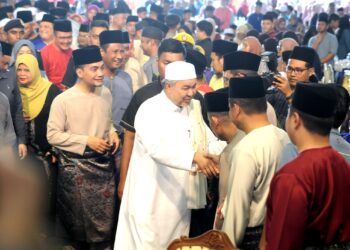AHMAD ZAHID Hamidi bersalaman dengan orang ramai sambil diiringi Onn Hafiz Ghazi pada Majlis Santunan Kasih Ramadan di Masjid Jamek Pekan Layang-Layang, Kluang.