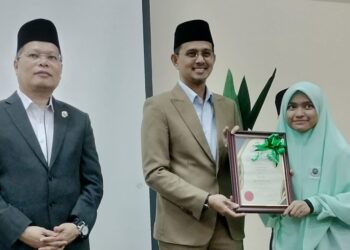 SITI AISHAH Aziz menerima surat penghargaan sebagai Pelajar Terbaik Lima Bidang SMA daripada Pengerusi Jawatankuasa Hal Ehwal Agama Johor, Mohd. Fared Mohd. Khalid selepas majlis pengumuman keputusan peperiksaan SMA dan SMRA di SMAK Johor di Kluang.