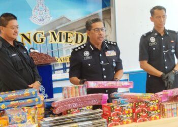 ISMAIL Dollah (tengah) menunjukkan sebahagian daripada bunga api dan mercun yang dirampas di sebuah rumah kosong di Parit Sulong, Batu Pahat.