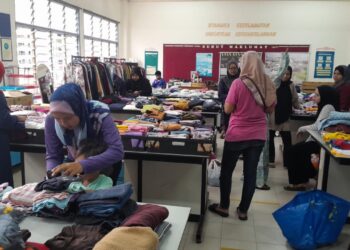 WARGA SK Bandar Putra meluangkan masa melihat pakaian dan barangan yang ditawarkan secara percuma dalam Program Kuru Kuru Kongsi Rezeki- Infak Aidilfitri di SK Bandar Putra, Segamat.