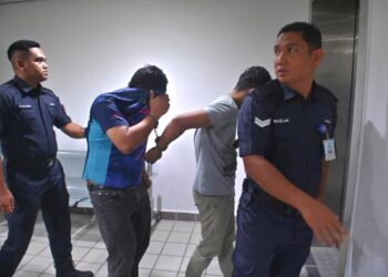 MOHD. Hasfyanizam (dua dari kiri) dan Mohamad Fazley (dua dari kanan) yang dituduh memperdagangkan wanita bagi eksploitasi seks dibawa keluar dari Mahkamah Sesyen Kuala Terengganu, hari ini. - UTUSAN/TENGKU DANISH PUQTRA HAIRRY