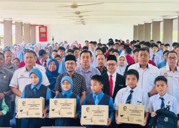 HARIS SALLEH Hamzah (depan, tengah) bersama tetamu dan penerimaan Bantuan Awal Persekolahan (BAP) di Sekolah Menengah Kebangsaan (SMK) Felda Padang Piol di Jerantut, Pahang. - FOTO/HARIS FADILAH AHMAD