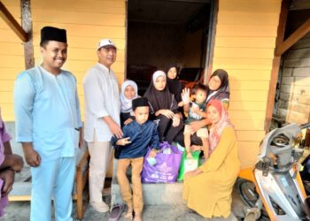 HASNI Mohammad (dua dari kiri) bersama penerima sumbangan program Temashor  Ramadan Majlis Belia Daerah Pontian di Kampung Sanglang, Pontian.