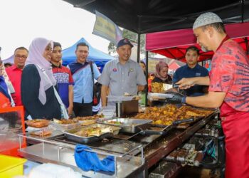 MOHD. JAFNI Md. Shukor (tengah) menyantuni para peniaga di Bazar Ramadan Jalan Enggang, Kulai.