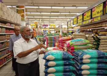 SYED Abu Hussin Hafiz Syed Abdul Fasal meninjau harga BPI yang dijual di sebuah pasar raya di Kuala Terengganu, hari ini. - UTUSAN/TENGKU DANISH BAHRI TENGKU YUSOFF