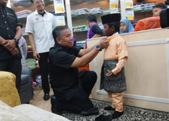 MOHAMAD AZMI Sabtu menyantuni seorang murid pada Program Tautan Kasih Ramadan anjuran Zakat Melaka dan PNMB di Bukit Piatu, Melaka. - UTUSAN/MUHAMMAD SHAHIZAM TAZALI