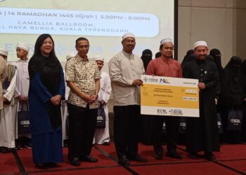 DARWIS Abdul Razak (dua dari kanan) menyampaikan sumbangan kepada wakil 
Madrasah Tabiyyah Islamiyah Darul Hijrah (kanan) pada Majlis Berbuka Puasa Bersama ECRL di Kuala Terengganu, malam tadi.