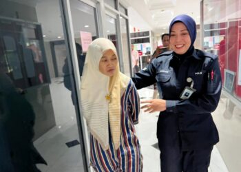 RASYIDAH Ramly (kiri) yang dituduh mencuri barang di sebuah pasar raya dibawa keluar dari Mahkamah Majistret Kuala Terengganu, hari ini. - UTUSAN/TENGKU DANISH BAHR TENGKU YUSOFF