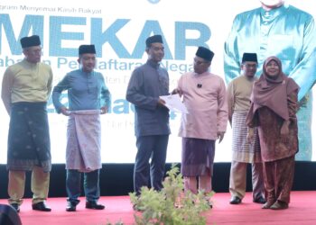 MUHAMMAD Ramadhan Abdullah (tiga kiri) menerima sijil kewarganegaraan daripada Saifuddin Nasution Ismail pada program Mekar di Masjid An-Nur, Pokok Sena. -UTUSAN/SHAHIR NOORDIN