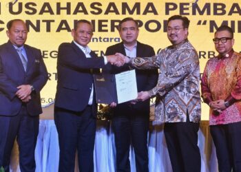 AMINUDDIN Harun (dua dari kiri) bertukar dokumen bersama Andrew (dua dari kanan) sambil disaksikan oleh Anthony Loke pada Majlis Menandatangani Perjanjian Usahasama Di Antara MBINS dengan Midport Holdings Bagi Cadangan Pembangunan Pelabuhan Kontena Pintar AI di Seremban hari ini.-UTUSAN/MOHD. SHAHJEHAN MAAMIN.