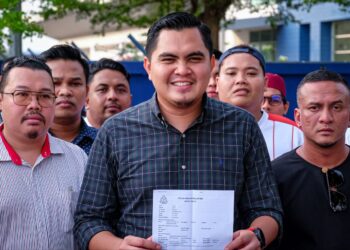 MUHAMAD AKMAL Saleh menunjukkan laporan polis dibuatnya di IPD Jasin, Melaka. - UTUSAN/SYAFEEQ AHMAD