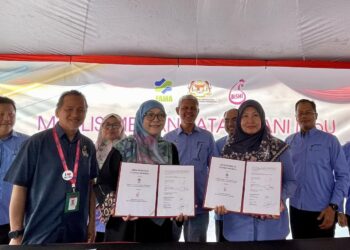 AMINUDDIN Zulkipli (belakang, tengah) menyaksikan majlis menandatangani MoU antara FAMA dan Ayam Bismi di Alor Setar.