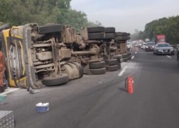 KEADAAN treler muatan tepung yang terbalik di Kilometer 292.1, Lebuh Raya Utara Selatan arah selatan dekat Simpang Pulai menyebabkan kesesakan teruk sejauh 23KM.- UTUSAN/IHSAN JBPM