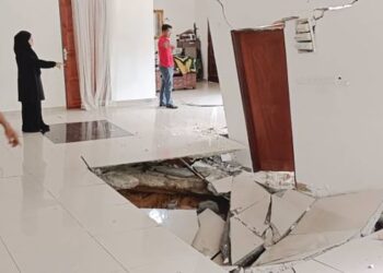 ZULKEFLY Mustaffa menunjukkan lantai rumahnya di Larkin Jaya yang mendap dan retak dalam kejadian minggu lalu.