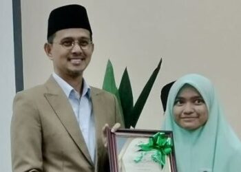 SITI AISHAH Aziz menerima sijil penghargaan sebagai Pelajar Terbaik Lima Bidang SMA daripada Pengerusi Jawatankuasa Hal Ehwal Agama Johor, Mohd. Fared Mohd. Khalid selepas majlis pengumuman keputusan peperiksaan SMA dan SMRA di SMAK Johor di Kluang.