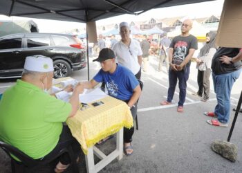 Seorang pembayar zakat menunaikan Rukun Islam Keempat itu ketika mengunjungi Bazar Ramadan Bandar Baru Uda, Johor Bahru, baru-baru ini. - UTUSAN/RAJA JAAFAR ALI