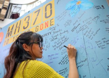SALAH seorang waris mangsa pesawat MH370 menulis nota sempena ulang tahun ke-10 kehilangan pesawat tersebut di Subang Jaya. - UTUSAN/SADDAM YUSOFF