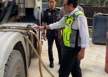 KAMALLUDIN Ismail melihat minyak diesel bersubsidi yang dirampas dalam serbuan di sebuah premis di Simpang 4, Hutan Melintang di Bagan Datuk semalam. - UTUSAN