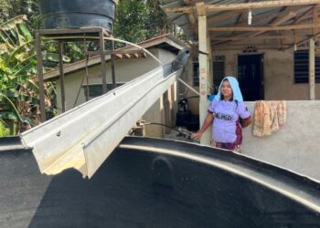 LAILY Jasin menunjukkan bekalan tadahan air hujan di rumahnya di Kampung Merlong di Rancangan Pengumpulan Semula (RPS) Kuala Betis, Gua Musang, Kelantan. – UTUSAN/AIMUNI TUAN LAH
