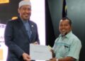 DR. IZANI Husin (kiri) menyampaikan surat lantikan kepada salah seorang kontraktor terpilih pada Majlis Cabutan Kerja Undi Mega JKR Cawangan Kejuruteraan Elektrik Negeri Kelantan di Kompleks Kota Darulnaim, Kota Bharu, semalam. – UTUSAN/MUSTAQIM MOHAMED