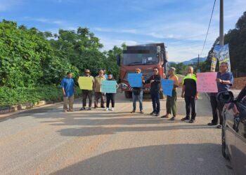 PENDUDUK membantah operasi mengangkut tanah menggunakan jalan utama kawasan perumahan di Hulu Kinta di Ipoh. - UTUSAN/SAYED HESHAM IDRIS