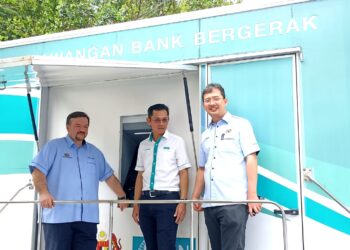 AMIR Hamzah Azizan (kiri) mengadakan lawatan di Bank Bergerak BSN di  Dewan Jelutong Hutan Lipur, Kuala Woh, Tapah hari ini. - UTUSAN