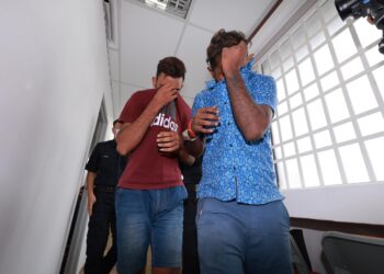 DUA lelaki mengaku tidak bersalah menyamar pegawai Imigresen ketika didakwa di Mahkamah Majistret Ipoh hari ini. - UTUSAN